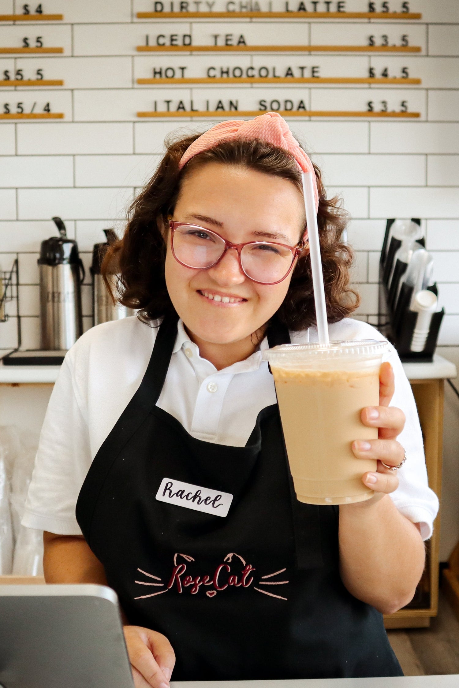 Rachel from Rose Cat Coffee Co smiles while serving an iced latte!